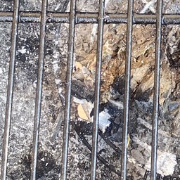 Parrilla de hierro de una Weber con la pátina y la ceniza del uso